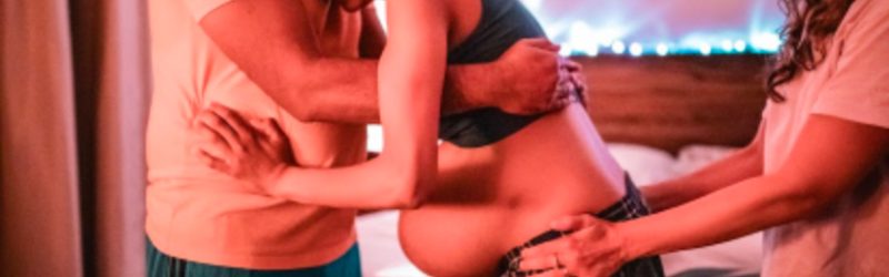A doula guiding a partner in providing emotional and physical support during labor