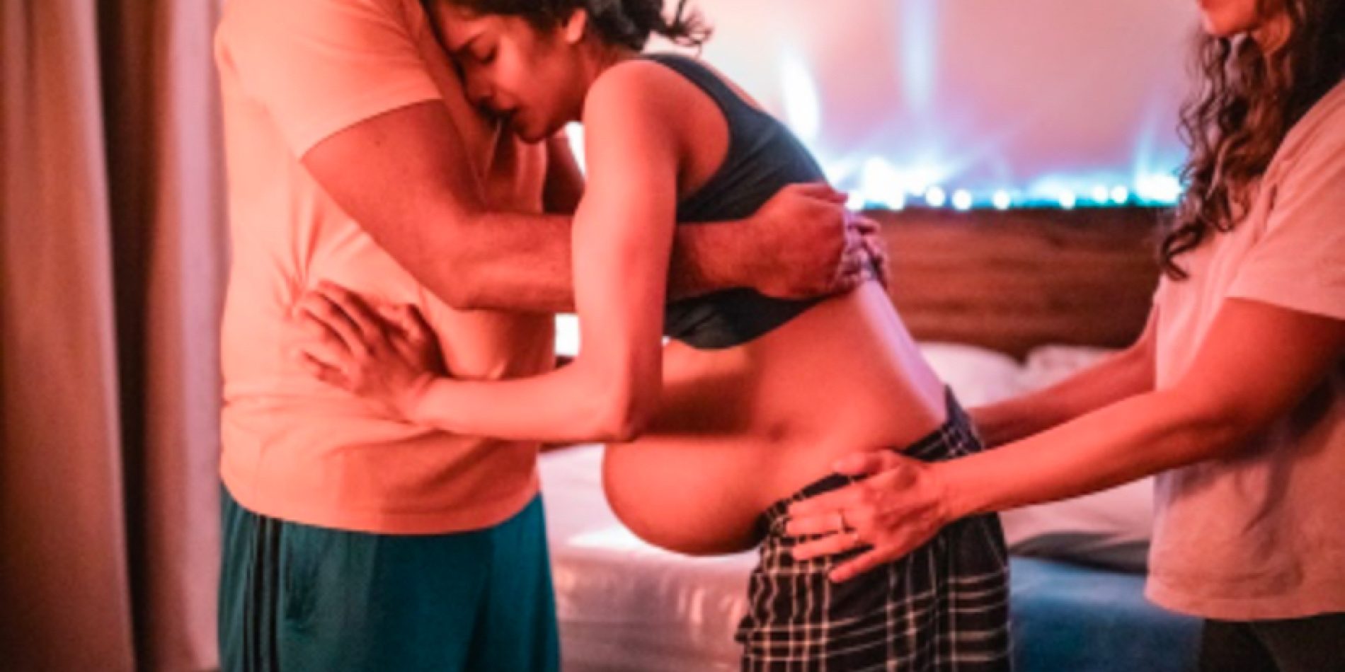 A doula guiding a partner in providing emotional and physical support during labor